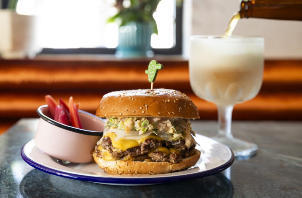 The Maximo smash burger pays homage to the longtime former tenant of its restaurant space — The Edloe Street Deli. (Photo by Julie Soefer)