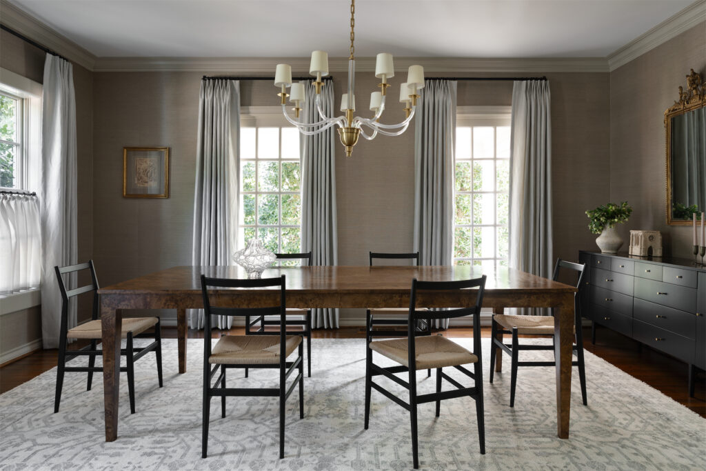 With grasscloth on the walls, Rogers & Goffigon menswear stripe fabric at the windows, and a massive burlwood dining table, the family dining room is cozy and slightly masculine. (Photo by Trevor Parker)