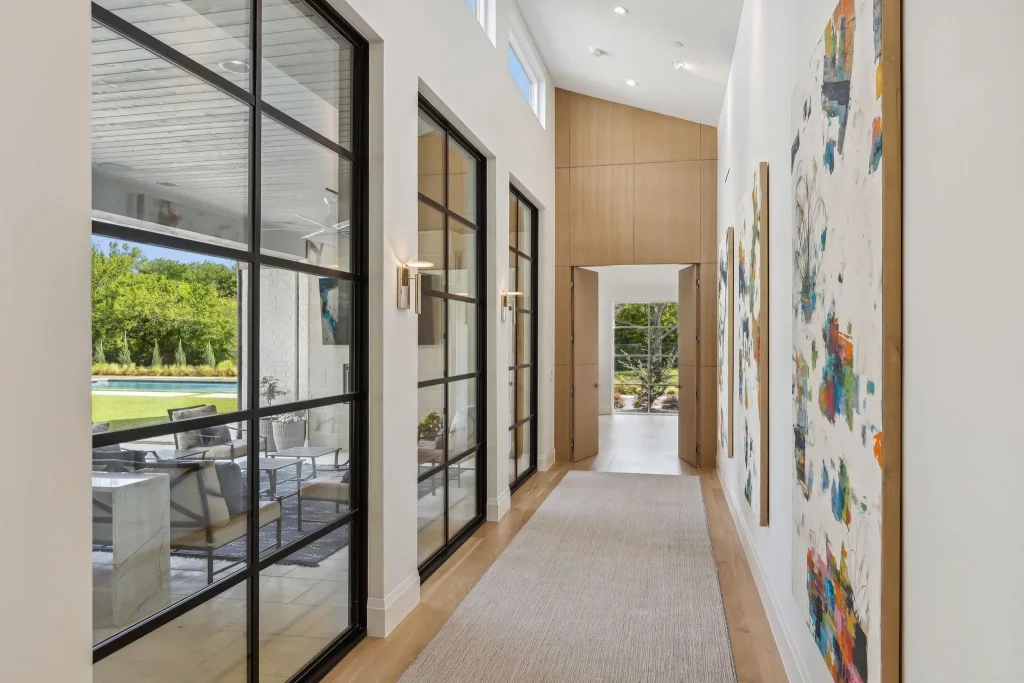 The hallway leading to the primary suite is bathed in light.