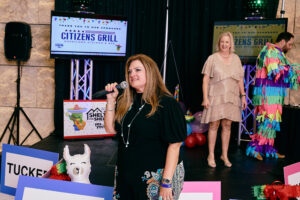 Michele Kooken, CEO of YES to YOUTH, addresses the crowd as Marlys Mulkey looks on.