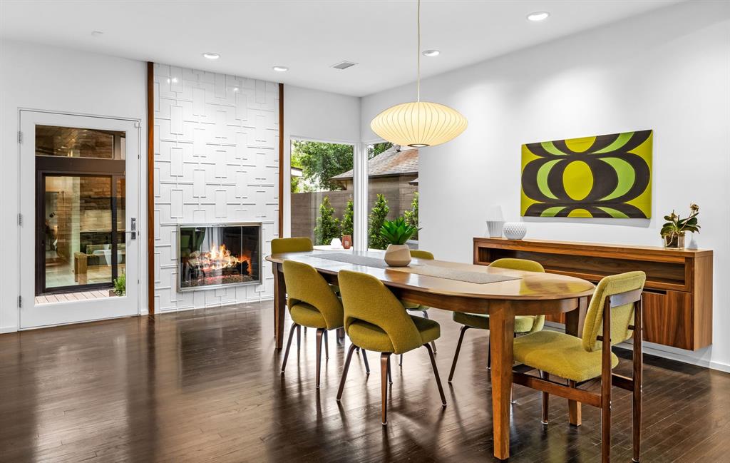 A bubble pendant and fireplace creates a mod aesthetic in the dining room.