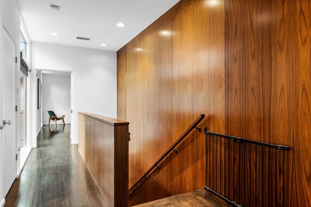 The stairwell  to the upstairs, which features a primary suite and three additional bedrooms.