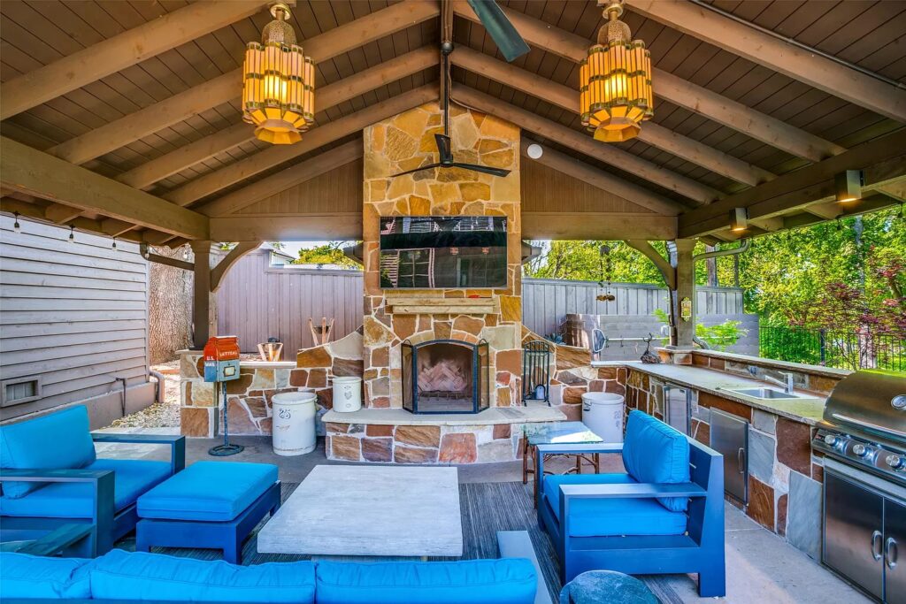 A cabana includes a towering fireplace and outdoor kitchen.