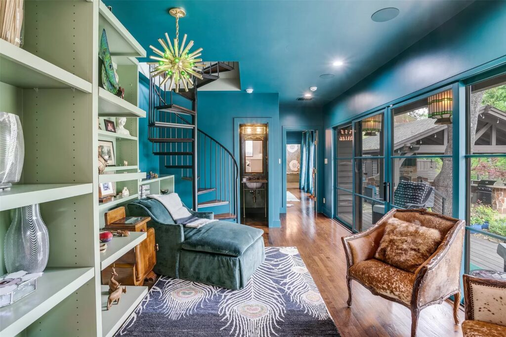 The sitting area of a lofted primary bedroom suite.