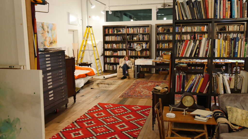 Artist Terrell James relaxes for a moment near the library within her studio. (Photo by Cameron Armstrong)