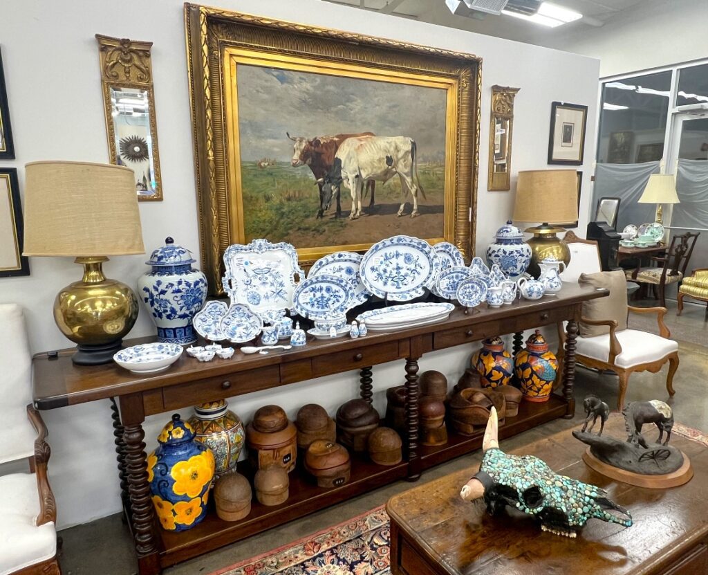 A collection of pots and fine china beneath an oil painting by Belgian artist Alfred Verwee. 