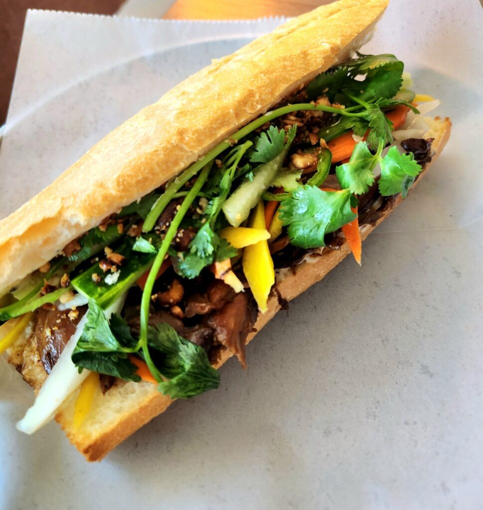 Duck Bahn Mi is on the lunch menu at Belly of the Beast. It is a braised duck leg with kewpie mayo, pickled veggies, cilantro and peanuts.
