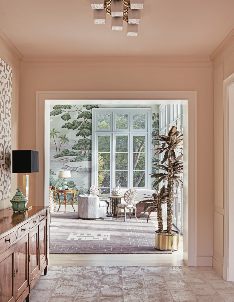 In a hallway off the entry, walls are painted Benjamin Moore Love Story pink. Ceiling fixture from John Gregory Studios. Mid- century brass palm tree from Ceylon et Cie.  (Photo by Richard Powers)