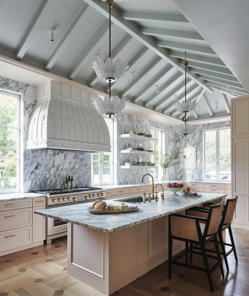 The kitchen’s custom range hood is by Casci Ornamental Plaster. Swedish 1940s Orrefors light pendants. Caned barstools from Burke Decor.  (Photo by Richard Powers)
