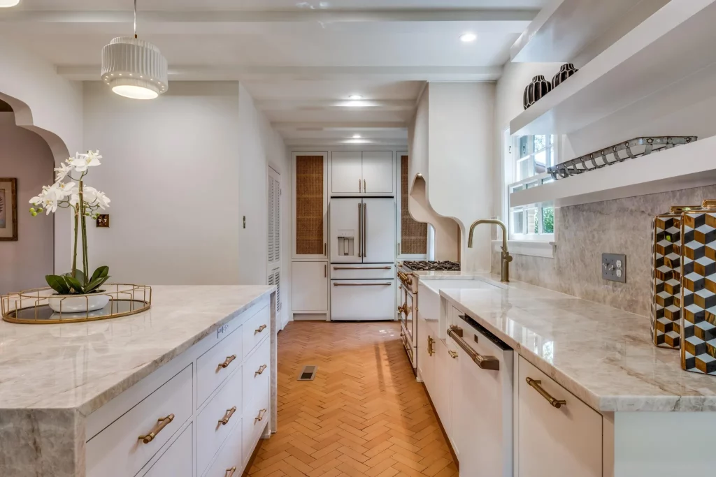 The kitchen features Taj Mahal quartzite for the island and counters and herringbone terracotta tile. 