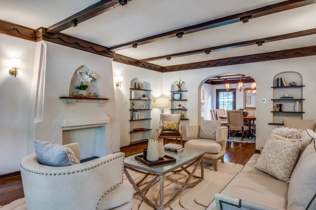 A large living area features a Spanish Colonial Revival-style fireplace.
