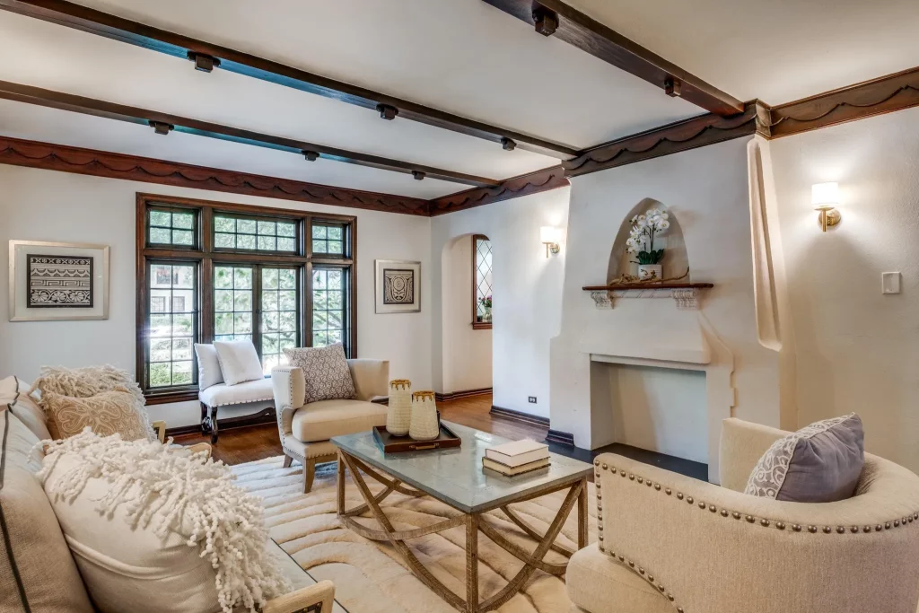 A large living area features a Spanish Colonial Revival-style fireplace.