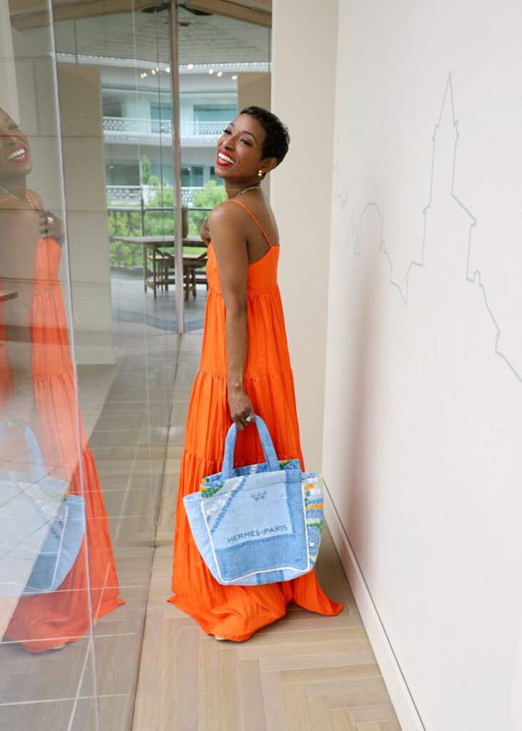This flowy Rose Ibiza orange tiered slip dress paired with a LilyEve vintage Hermes towel tote is the perfect look.