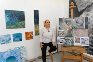 Arielle Masson surrounded by her paintings (Photo by Sofia Westerman)