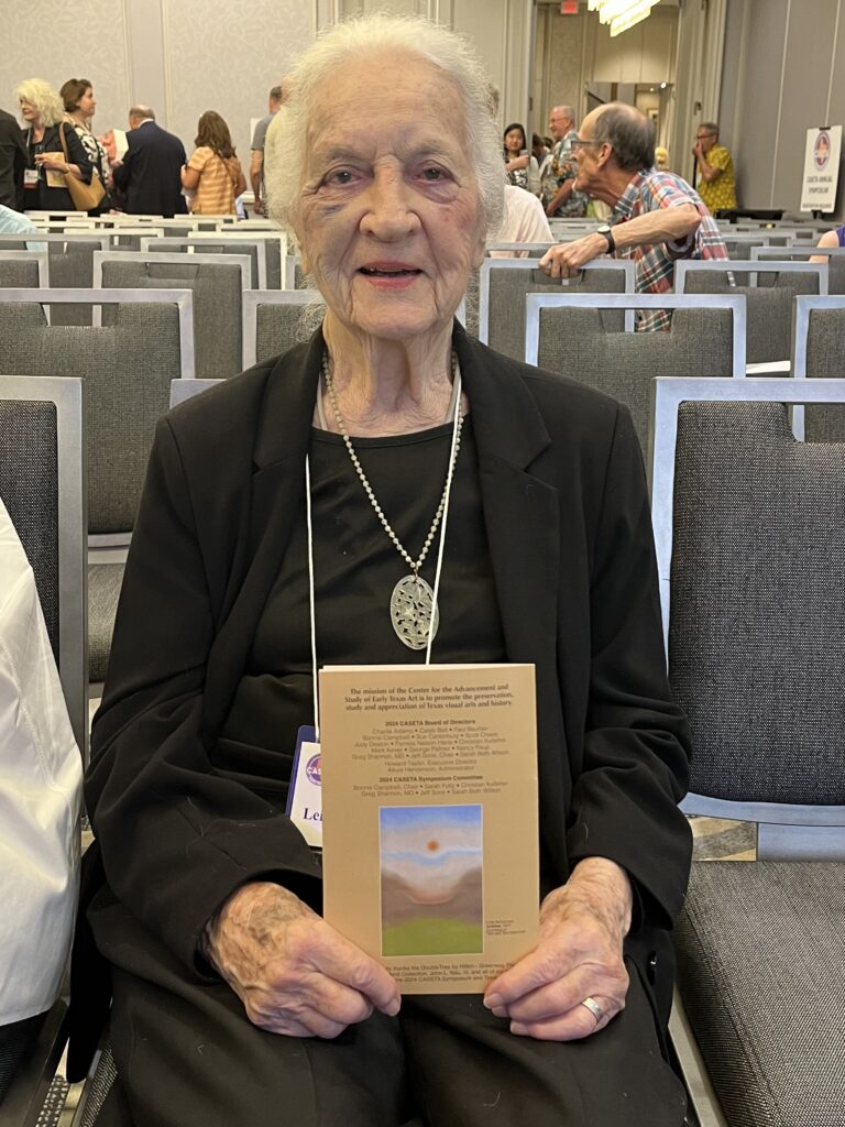 Leila McConnell holds up the evening program which features one of her paintings at CASETA 2024. (Photo by Jenna Baer)
