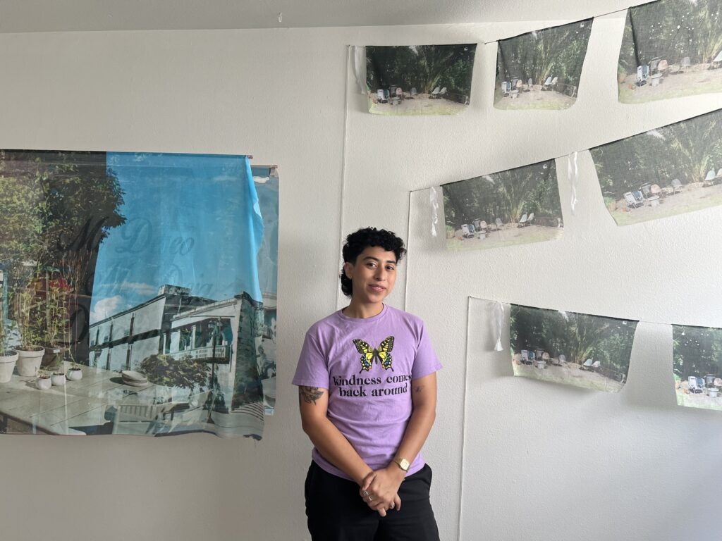 Sol Diaz-Peña stands amid their landscape photos which they printed on fabric at FLATS' "Interwoven." (Photo by Catherine D. Anspon)