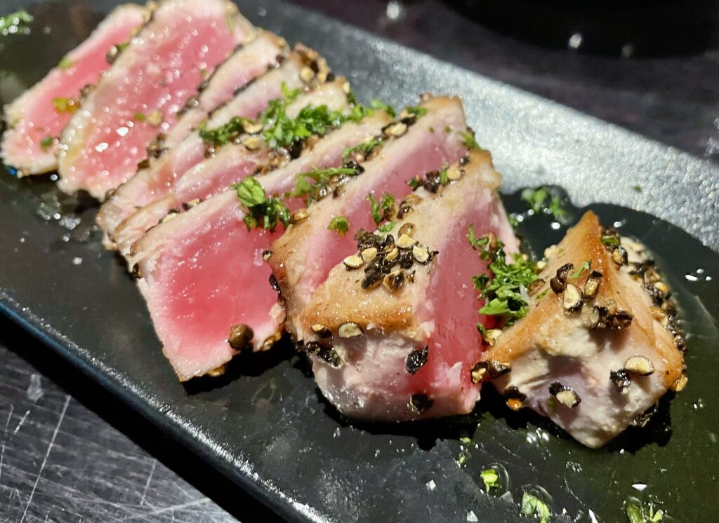 The atún a la plancha was a hearty portion of seared tuna, crusted in coarse black pepper and plated in olive oil. (Photo by Courtney Dabney)