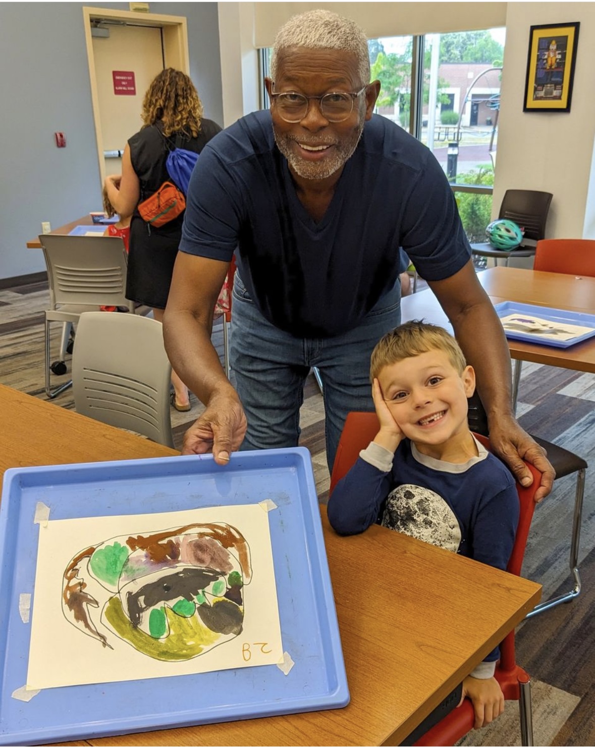 loyd Newsum shows off the work of a young artist as part of the Art Cart program connected to the Madison Museum of Contemporary Art in Madison, Wisconsin. Newsum's 2023 solo retrospective, <em>Evolution of Sight</em>, was presented by MMoCA. (Courtesy MMoCA)
