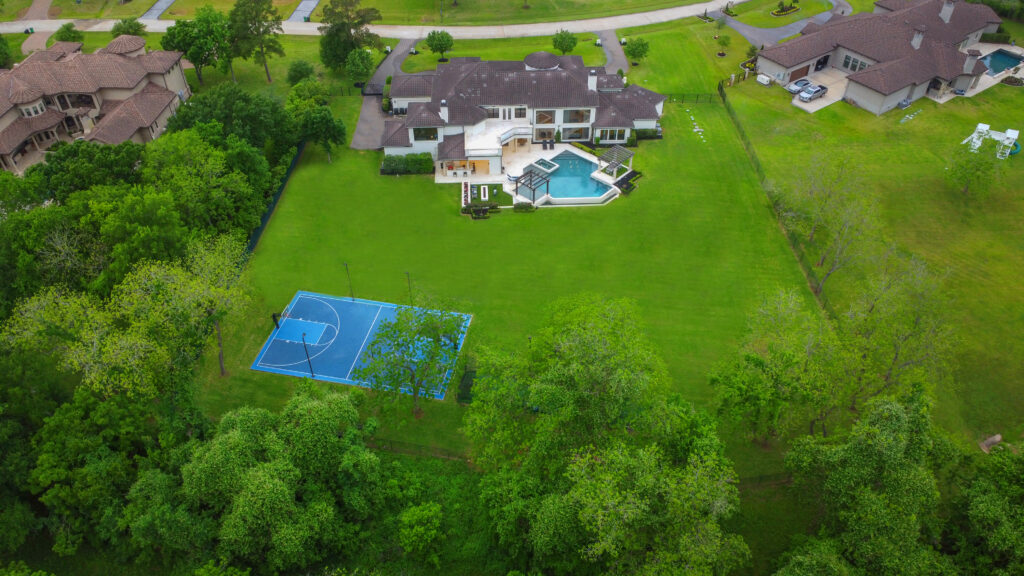 The outdoor basketball court at 6650 Whitehill in Richmond, Texas, is supplemented by baseball batting cages. (Photo by HDR Photography for Compass)
