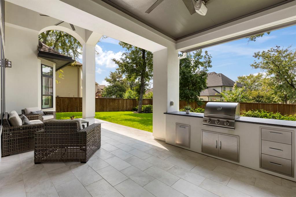 The backyard includes a summer kitchen and covered lounge space, with ample space to design your own custom swimming pool.