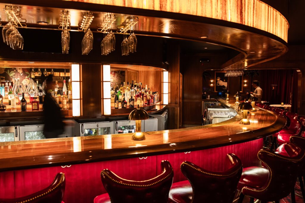 Step inside the 8,500 square-foot space and take in the moody, dimly lit space with its polished wood-topped bar, where the dining rooms are adorned with heavy scarlet-colored drapes, foxed mirrors, and a Campbell clan, red plaid carpet underfoot. (Photo by Becca Wright)