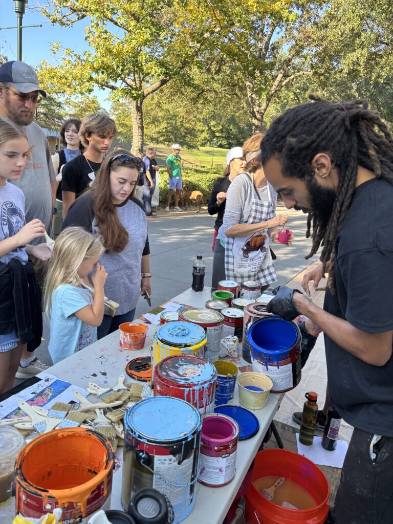 Community Paint Day allowed people walking near The Waterway to get involved in painting the 50th anniversary mural too. (Photo by Laura Landsbaum)