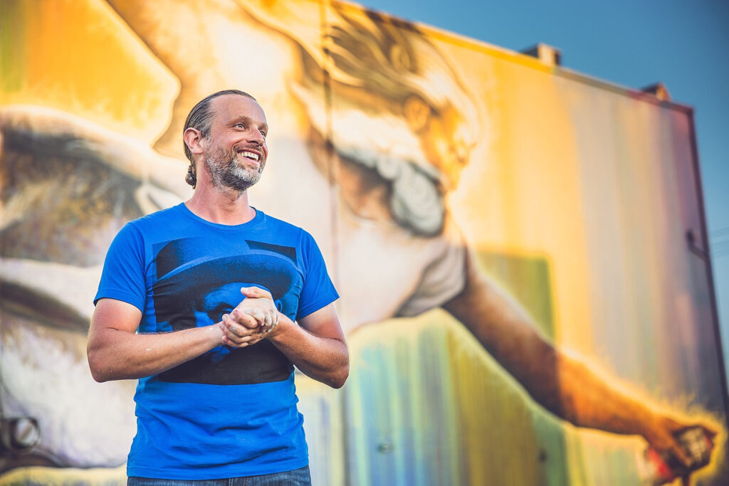 Sebastien "Mr. D 1987" Boileau stands in front of his mural “Preservons la Creation,” 2014.