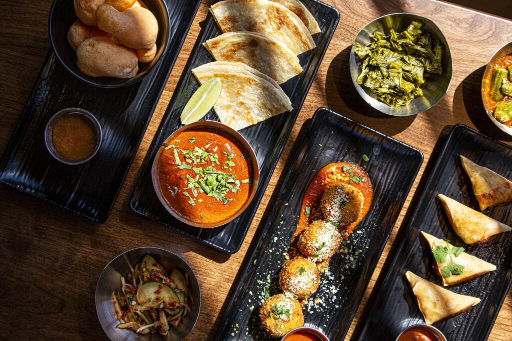 Traveler's Cart offers an array of street snacks, including butter chicken samosas, arancini alla carbonara and roti canai served with curry sauce. (Photo by Jenn Duncan)