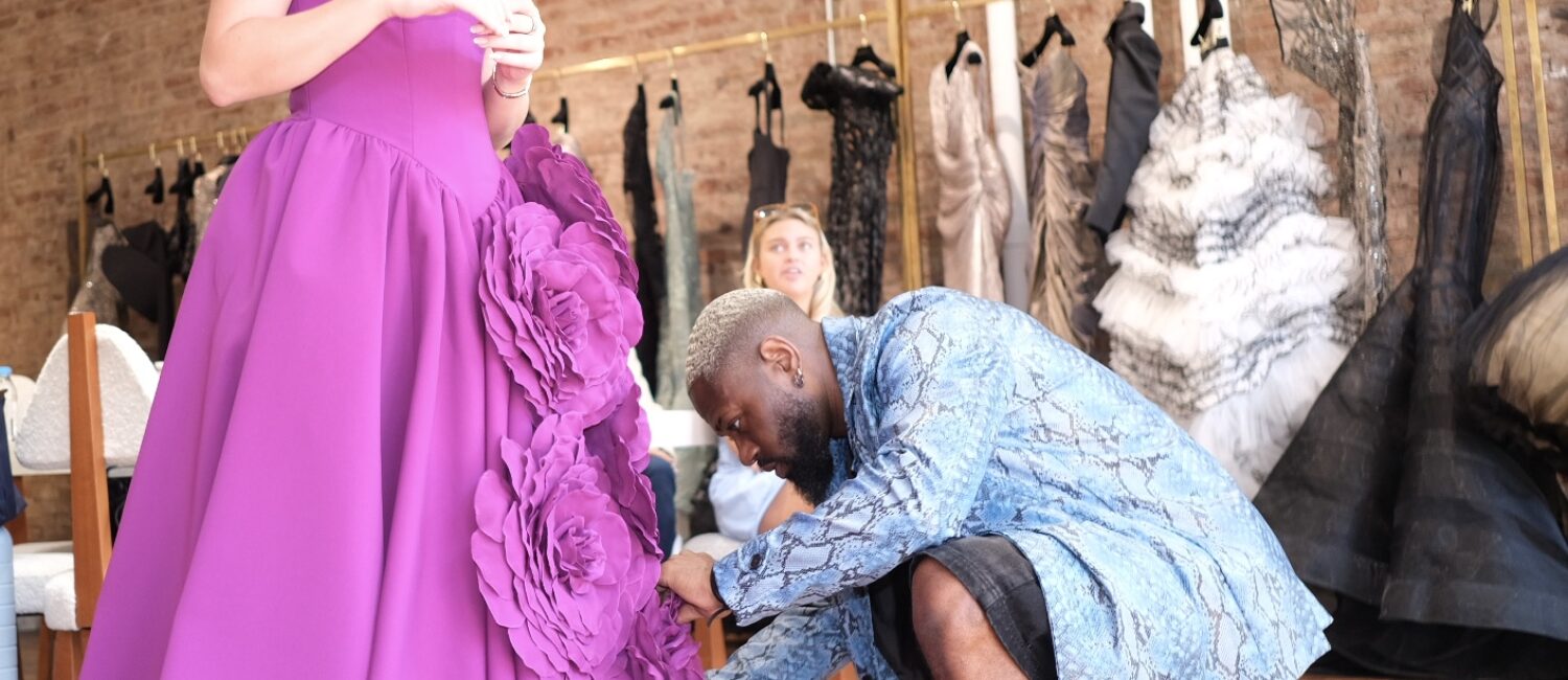 Designer Carl Curry works on Fort Worth Debutante Emily Kate Bell’s raspberry dress at Christian Siriano