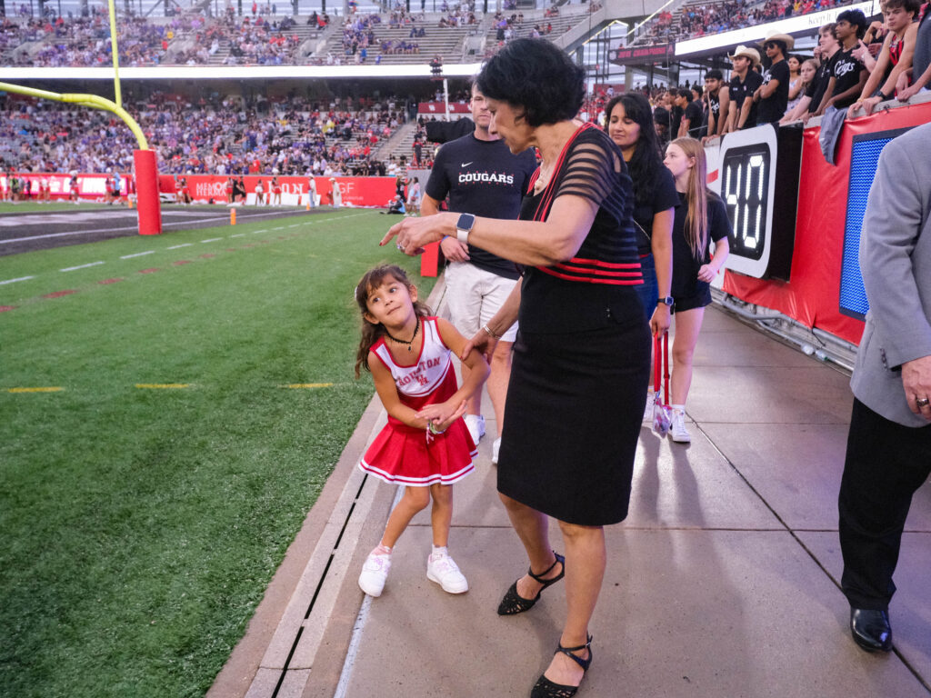 University of Houston president Renu Khator leads her granddaughter around the stadium to greet fans. (Photo by F. Carter Smith)
