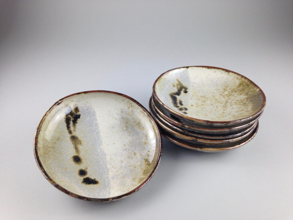 This set of six stoneware small plates showcases beautiful shino and nuka glazes for a timeless, artisan look. (Photo courtesy Linda Perez Ceramics)