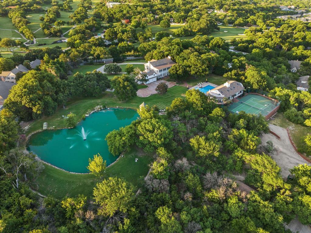 The grounds at 4132 Edgehill Road include a private pond with a gazebo, a tennis court next to a 7,000-square-foot multi-use space for parties, and a pool and pool house with a covered patio and living quarters.