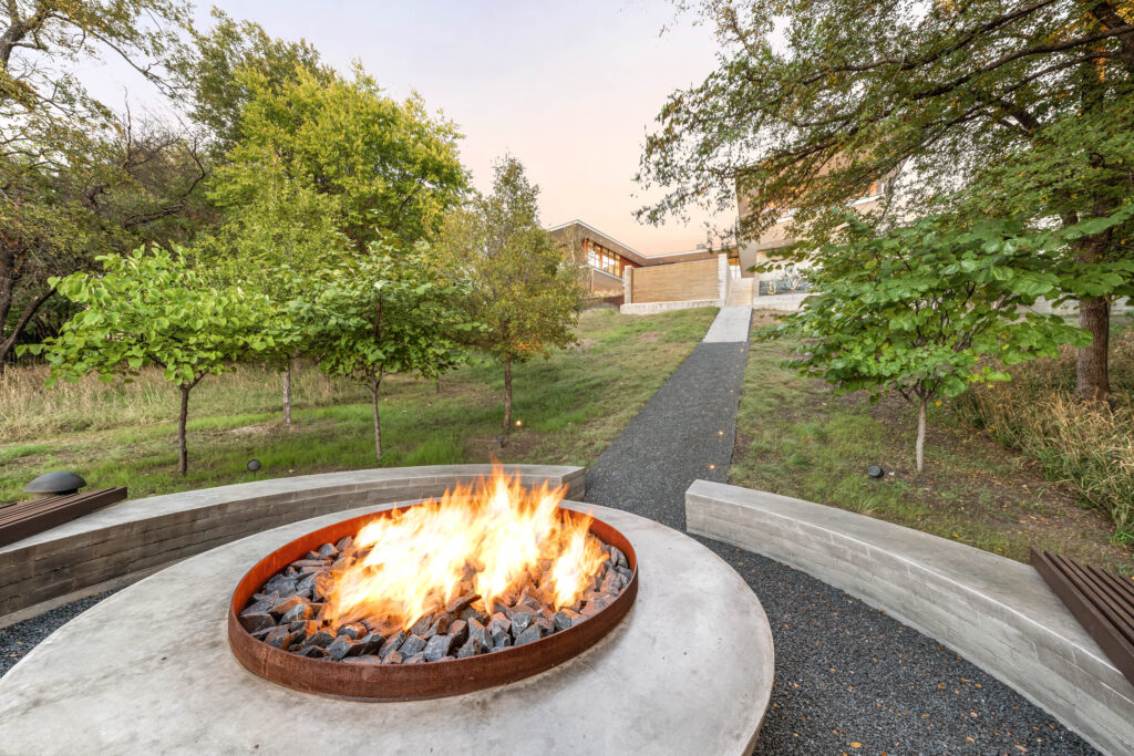 A winding pathway leads to a secluded firepit, offering a tranquil space to unwind and connect with nature. (Courtesy)