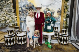 Adair Winget, Child Life specialist, with Melman, new Pawsitive Play dog. Posed with fashion santa and a holiday elf; Photo by Johnny Than