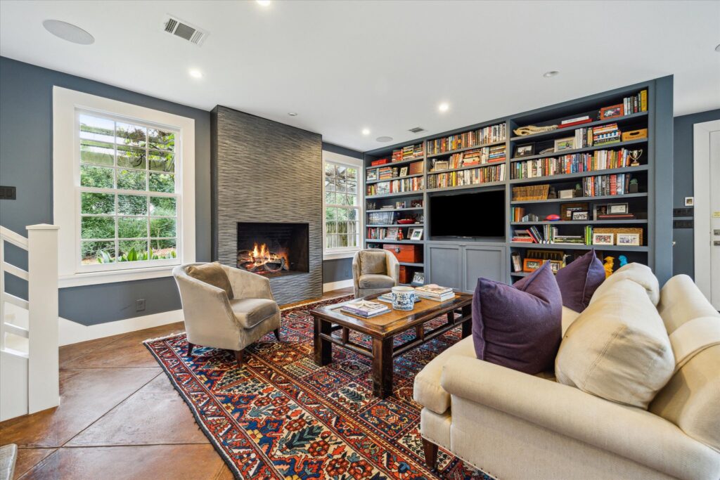 The den at 8899 Sandringham in Houston's Bayou Woods subdivision has its own fireplace (Photo by TK Images/Compass)