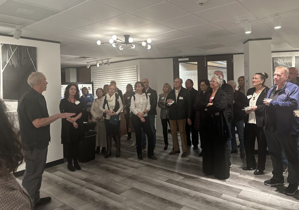 Martin Amorous, left, described creating art at the opening reception for his solo exhibit "The Poetry of Gravity" at The Woodlands Art Council's offices on Jan. 14.