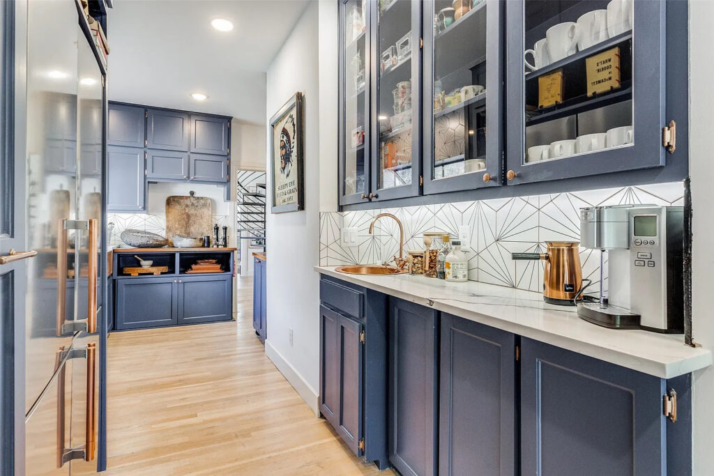 The appliances and high-end finishes in the eat-in chef's kitchen (complete with blue cabinets and exposed shelving) make it appear large and luxe.