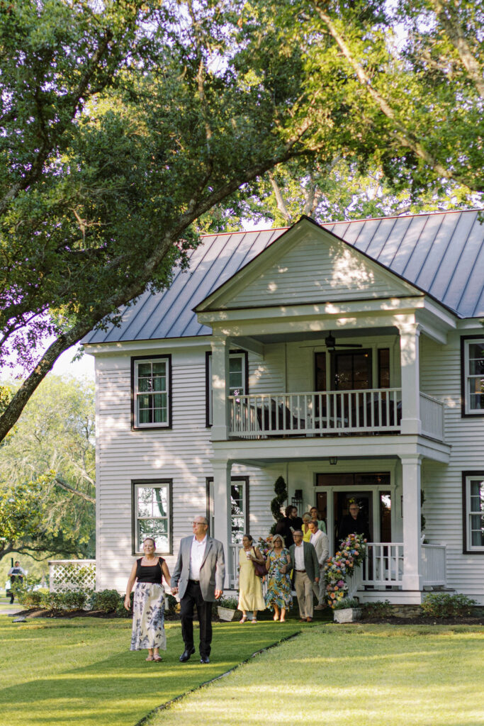 Guests move from the elaborate farm house to the lake's edge for the ceremony.  (Photo by Joseph West Photography)