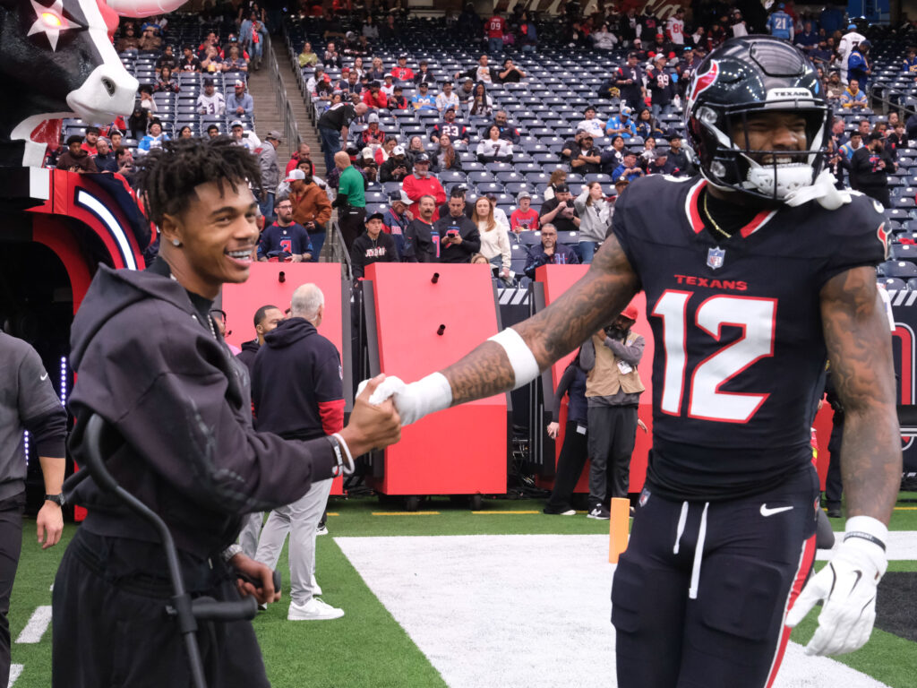 Houston Texans receiver Nico Collins (12) got some love from injured Texan and UH great Tank Dell. (Photo by F. Carter Smith)