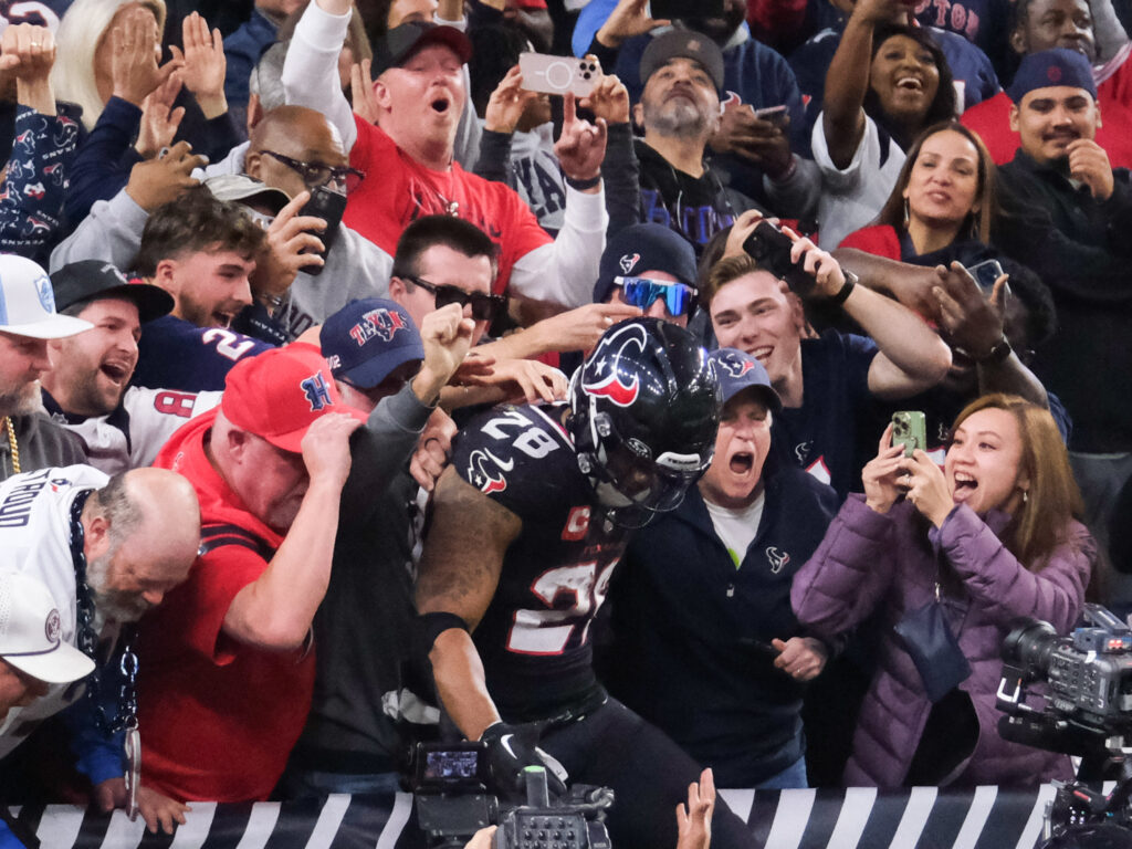 Houston Texans running back Joe Mixon leaped into the NRG Stadium stands after scoring a playoff touchdown. (Photo by F. Carter Smith)