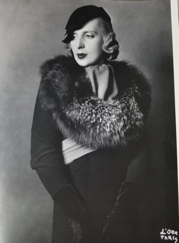 Tamara de Lempicka in a coat by Lucien Lelong and a hat by Rose Descat, 1933. (From the book Tamara de Lempicka by Gioia Mori and Furio Rinaldi, Yale University Press © 2024. Photo by Madame d’Ora)