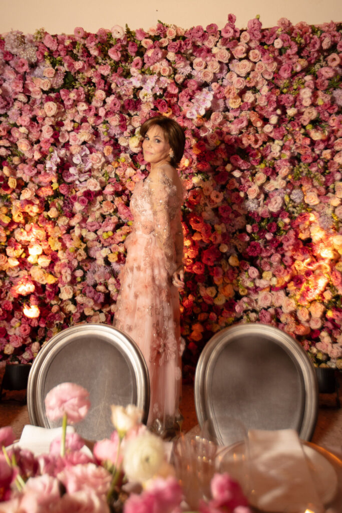 Blossoms on the flower wall reflect the dinner table florals at the wedding reception dinner at Villa Verano in Puerto Vallarta. (Photo by Kara Martinez)