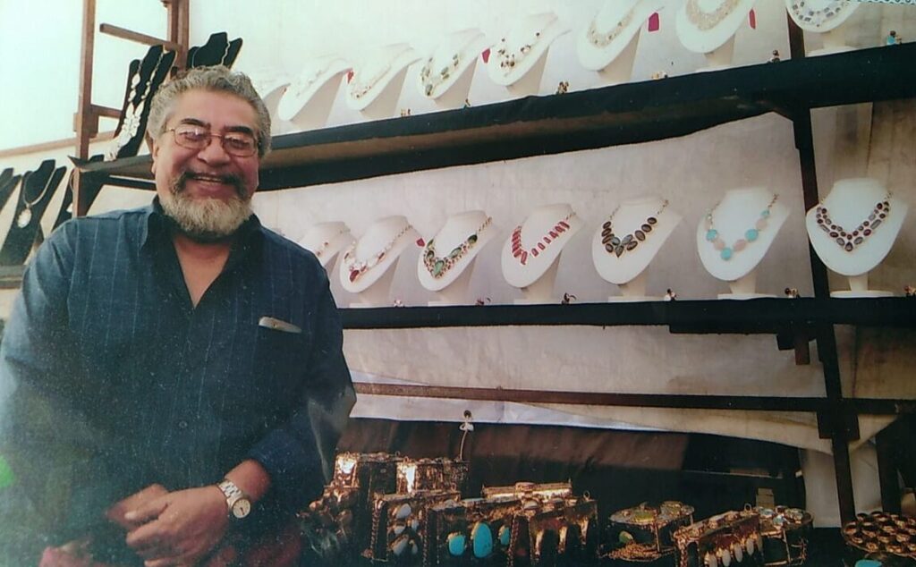 Marino Antonio Torres Hernández, founder and master artisan, stands proudly with the handcrafted purses and necklaces he created. His dedication and craftsmanship laid the foundation for a family tradition that continues to this day. (Photo courtesy Gabriela Torres Zaragoza)
