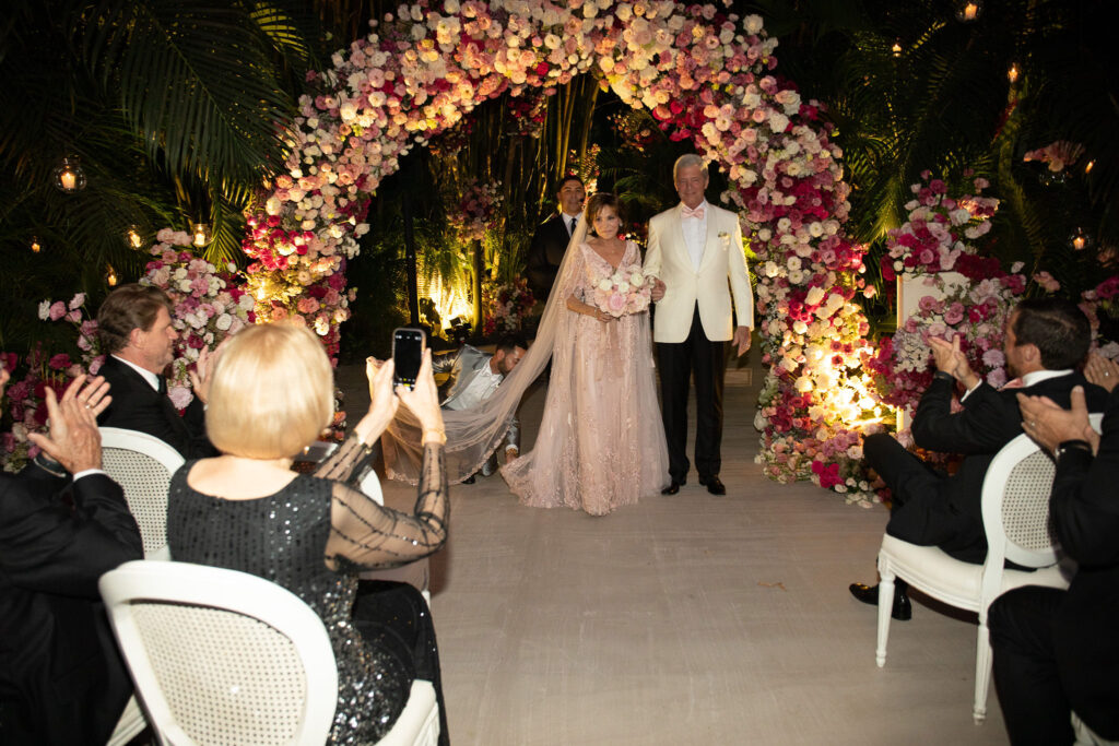 The newlyweds make their way to the reception overlooking the Pacific Ocean. (Photo by Kara Martinez)