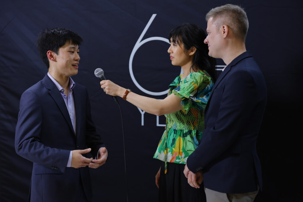 Competitor Andrew Li is interviewed by Elizabeth Joy Roe and Greg Anderson after his  performance in the Preliminary round of The Sixteenth Cliburn International Piano Competition in Van Cliburn Concert Hall. (Photo by Ralph Lauer)