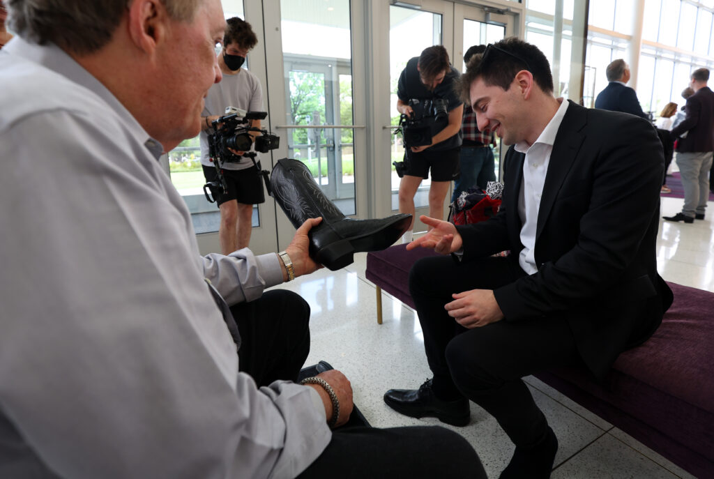 Competitor Denis Linnik is fitted for a new pair of boots at orientation for The Sixteenth Cliburn International Piano Competition at the TCU Music Hall in Fort Worth, Texas. (Photo by Richard Rodriguez)