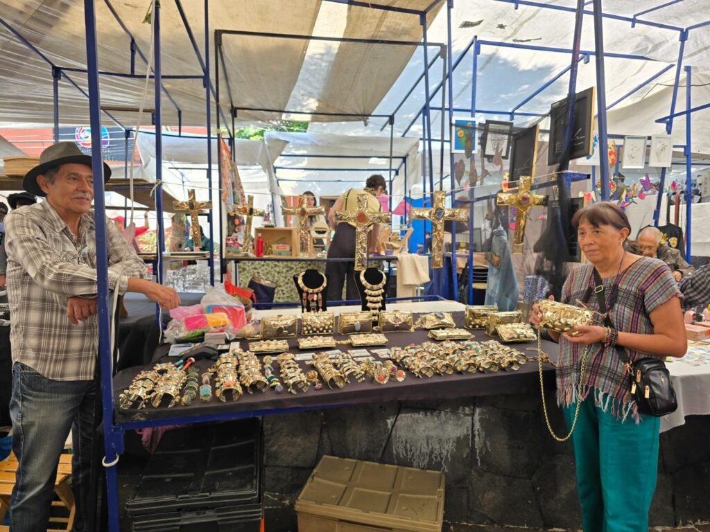 Jesús Casanova and the family matriarch, Antonieta Zaragoza Torres, stand at their San Ángel Market booth, proudly displaying their family's handcrafted goods. (Photo courtesy Gabriela Torres Zaragoza)