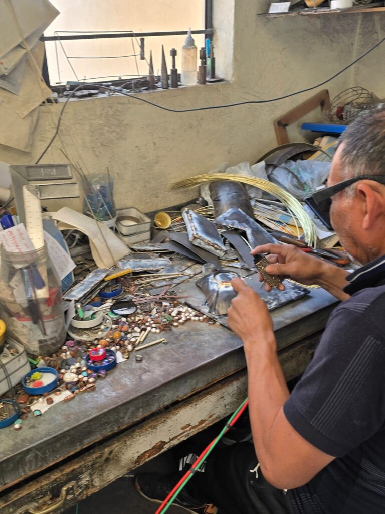 Germán Zurita carefully works on a purse, surrounded by the materials and tools essential to creating each handmade piece. Each step is vital to ensuring the quality and craftsmanship that defines their tradition. (Photo courtesy Gabriela Torres Zaragoza)