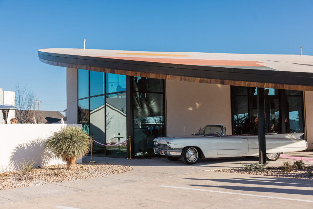 A 1960 Cadillac sits outside the new luxury motel in Stephenville, Interstate Inn. (Photo by Sara Forrest)