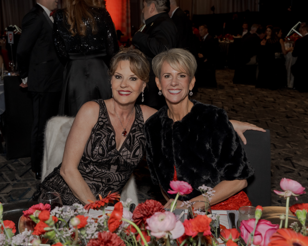 Jill Barber and Mari Harvey enjoy a moment at their table during the Heart Ball at The Woodlands Waterway Marriott. (Photo by 209 Photobooth Company)